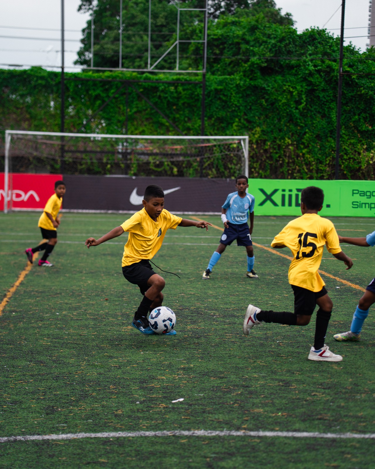 Jugador infantil de AD Curundú conduce el balón durante un partido, destacado por The Duke Chronicle